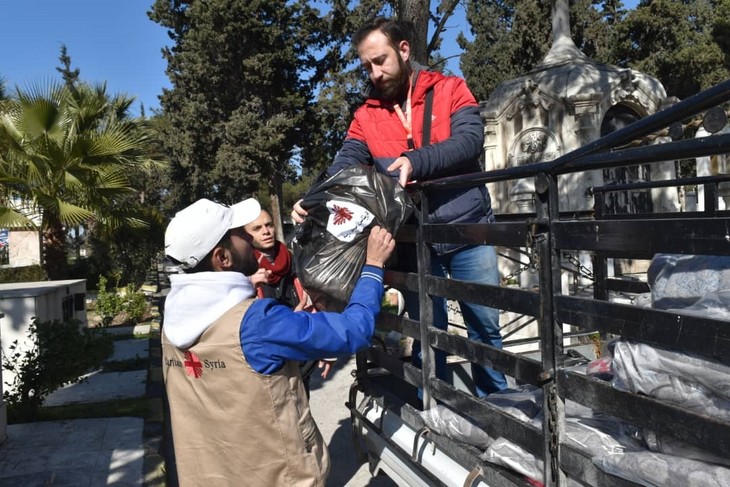 Hilfsgüterverteilung von Caritas Syrien nach dem Erdbeben. An einem Friedhof in Aleppo, auf dem acht Familien in einer kleinen Kirche Unterschlupf gefunden haben, reichen Helfer Decken aus. © Caritas international