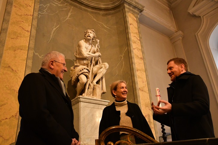 Freuen sich über die gelungene Wiederaufstellung der prächtigen Statue am Taufbrunnen der Kathedrale (v.l.n.r.): Bischof Heinrich Timmerevers, Generaldirektorin Marion Ackermann und Ministerpräsident Michael Kretschmer. © Michael Baudisch