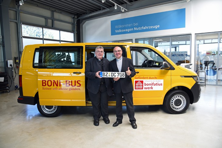Monsignore Georg Austen und Diakon Stefan Klose vor dem neuen BONI-Bus. © Simon Helmers/Bonifatiuswerk