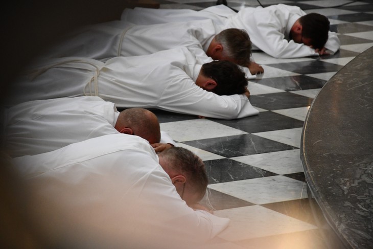 Die Weihekandidaten liegen ausgestreckt vor dem Altar auf dem Boden: Ein Zeichen der Demut und Hingabe. © Michael Baudisch