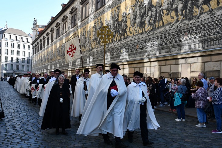 Mitglieder des päpstlichen Ordens ziehen am Fürstenzug in Dresden entlang zum Gottesdienst in der Kathedrale. © Michael Baudisch