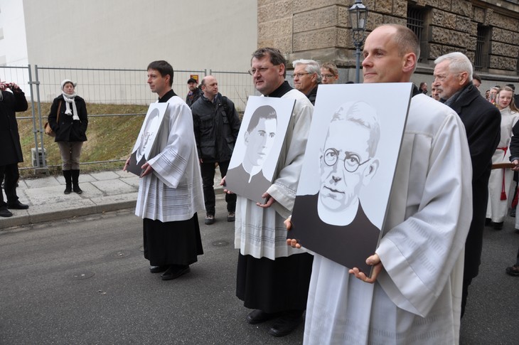 Das Bild von Pfarrer Aloys Scholze (rechts) trug Pfarrer Bertram Wolf 2011 - damals noch als Pfarrer von Leutersdorf - zur Überführung der Urnen der im KZ Dachau ums Leben gekommenen Seelsorger des Bistums durch Dresden. Die Porträtbilder (v.l.n.r.) von Bernhard Wensch und Alojs Andritzki trugen der damalige Bistumsjugendseelsorger Ralph Kochinka und der damalige Pfarrer von Radibor Stephan Delan. © Norbert Büchner