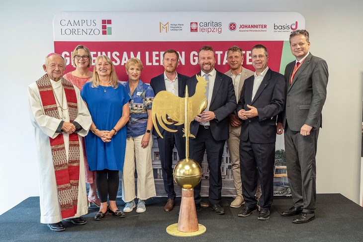 Der gold glänzende Wetterhahn als symbolischer letzter Baustein wird feierlich übergeben (v. r. n. l. Bischof em. Joachim Reinelt, Eva Maria Welskop-Deffaa, Petra Köpping, Dr. Martina Münch, Michael Kretschmer, Lars Menzel, Jörg Wimmer, Pfarrer Thomas Hajek, Tobias Strieder © Eric Kemnitz
