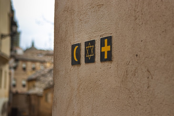 Symbole der drei abrahamitischen Religionen an einer Hauswand. © Foto von Noah Holm auf Unsplash